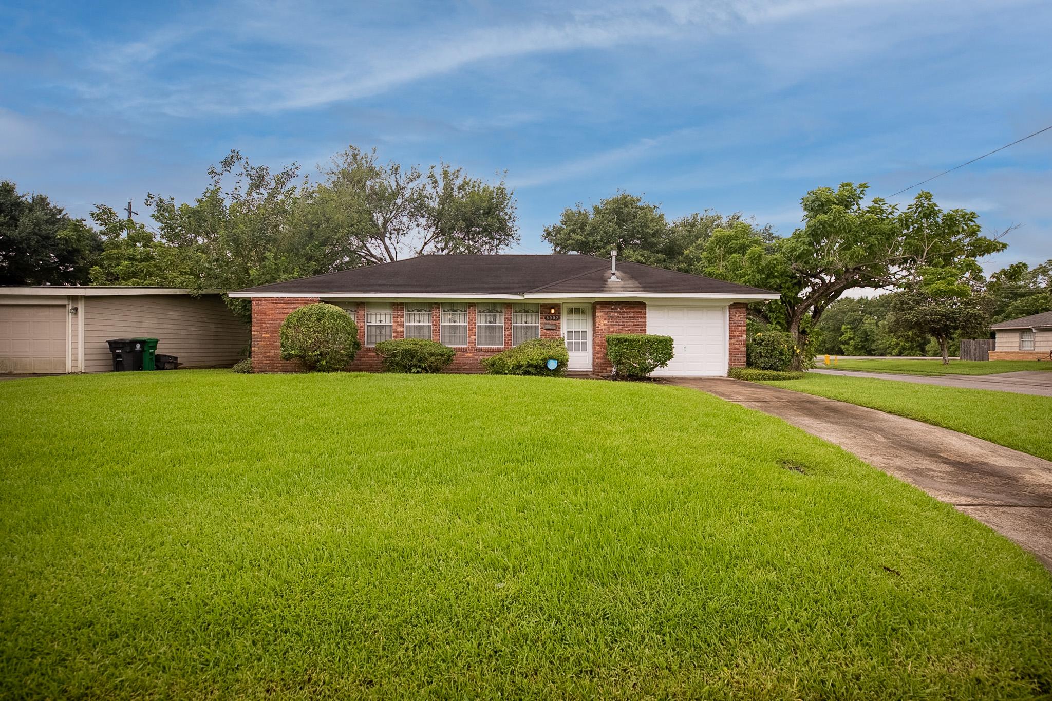 Real estate photography of residential home's exterior front with blue skies.