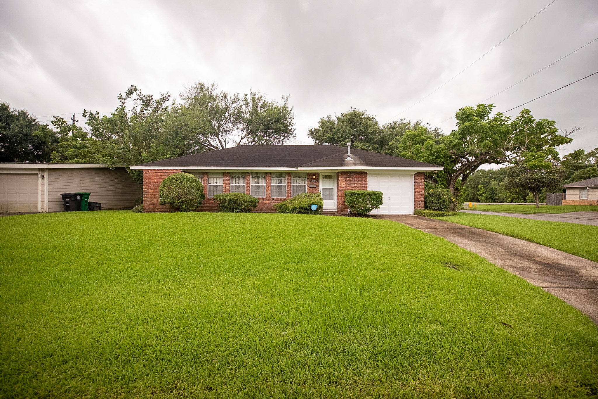 Real estate photography of residential home's exterior front with grey skies.
